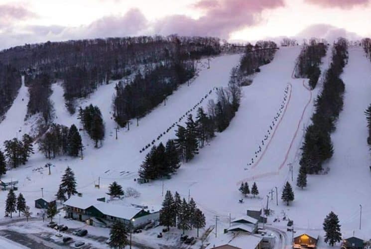 Aerial view of a small ski slope covered in snow at dusk