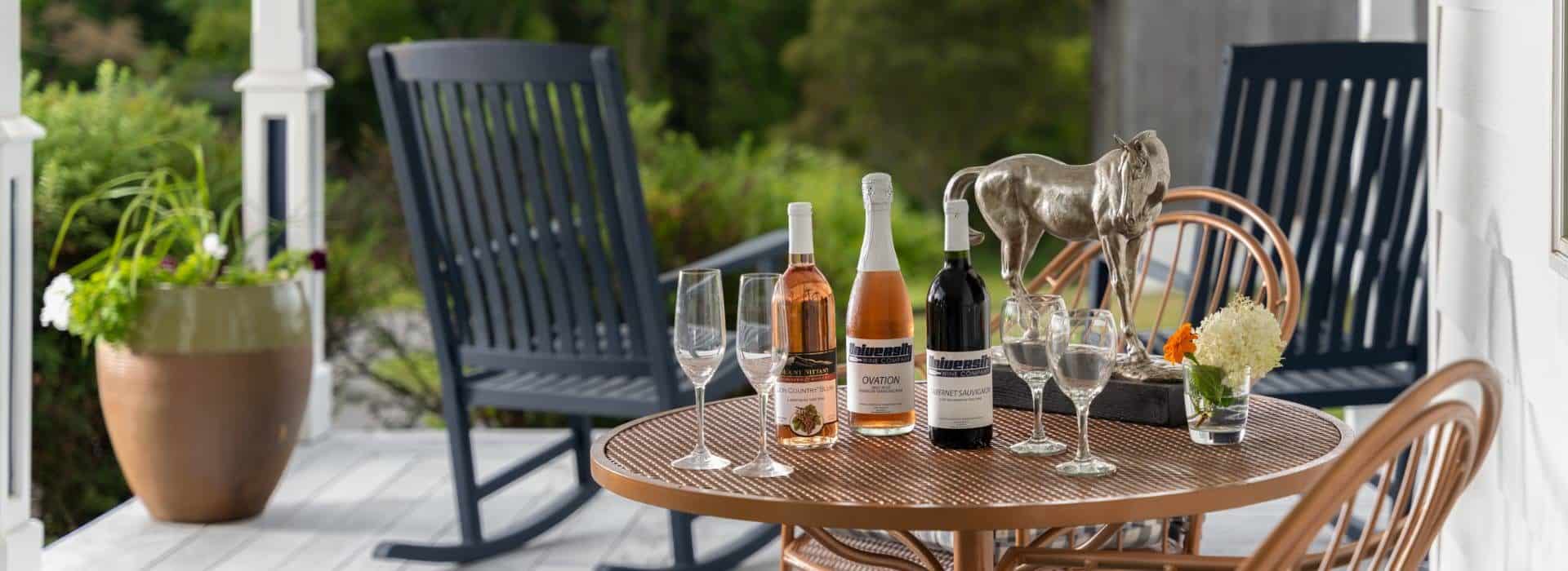 Close up view of copper patio table with multiple bottles of wine and wine glasses